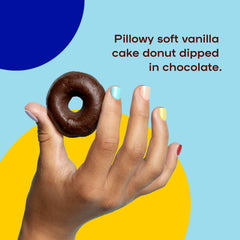 A hand holds up a chocolate dipped donut